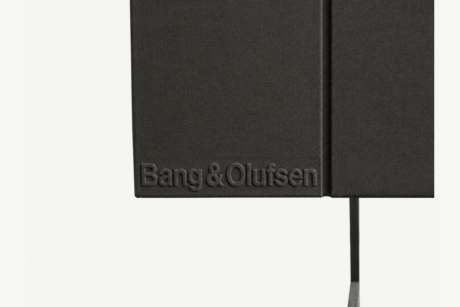 Primer plano del logotipo Bang & Olufsen en relieve sobre la tela de la rejilla